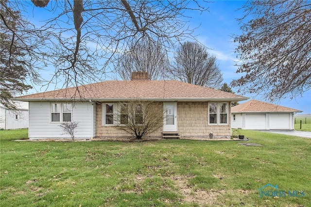 ranch-style home with a chimney, a front lawn, an outbuilding, a garage, and a shingled roof