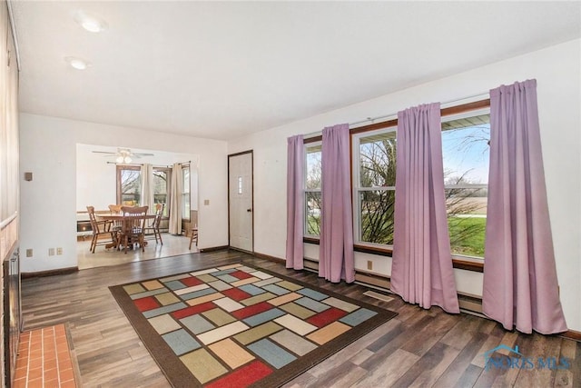 foyer featuring baseboards, a ceiling fan, and wood finished floors