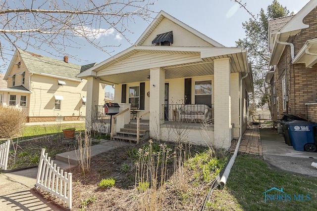 bungalow-style house featuring brick siding and covered porch