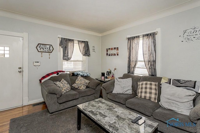 living room with visible vents, wood finished floors, and a healthy amount of sunlight