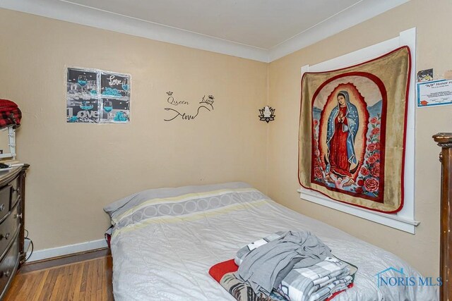 bedroom with baseboards and wood finished floors
