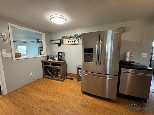 kitchen featuring appliances with stainless steel finishes, wood finished floors, and a ceiling fan