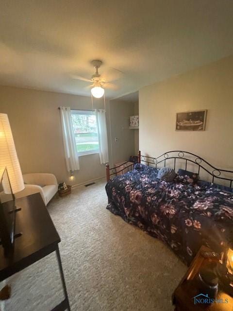 carpeted bedroom featuring visible vents, baseboards, and a ceiling fan