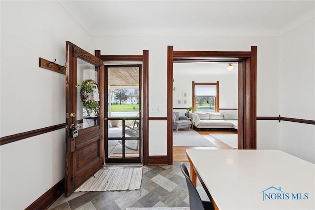 doorway to outside featuring baseboards