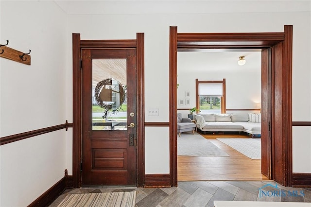 doorway to outside featuring baseboards and wood finished floors