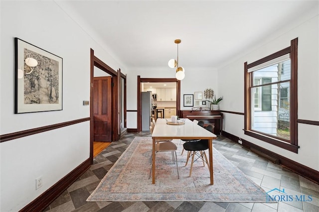 dining area with a barn door and baseboards