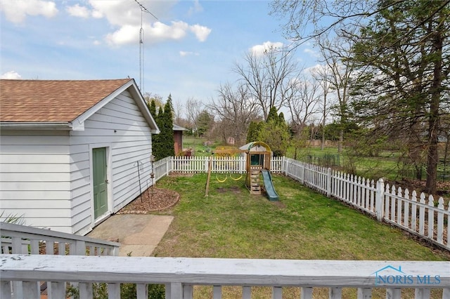 view of yard with a fenced backyard and a playground