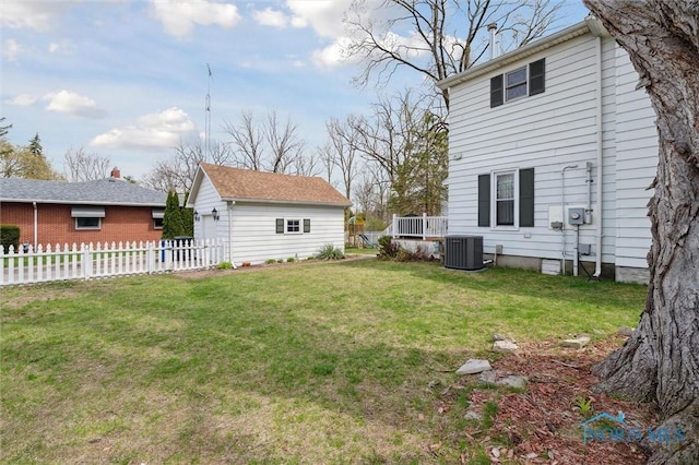 view of yard featuring an outbuilding, fence, and central air condition unit