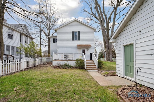 rear view of property with a yard, a deck, and a fenced backyard