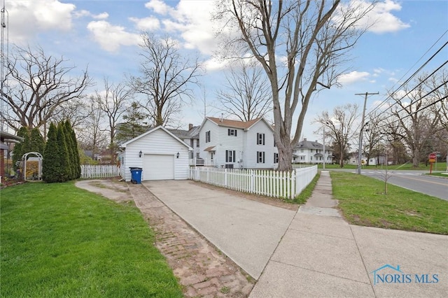 view of side of property featuring a residential view, an outdoor structure, driveway, a fenced front yard, and a yard