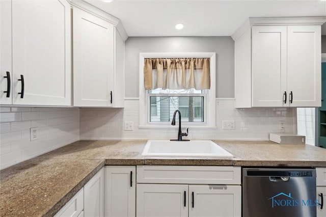 kitchen featuring stainless steel dishwasher, white cabinets, and a sink