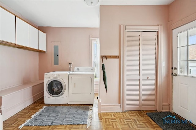 clothes washing area with independent washer and dryer and cabinet space