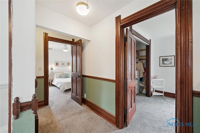 hall featuring baseboards and carpet