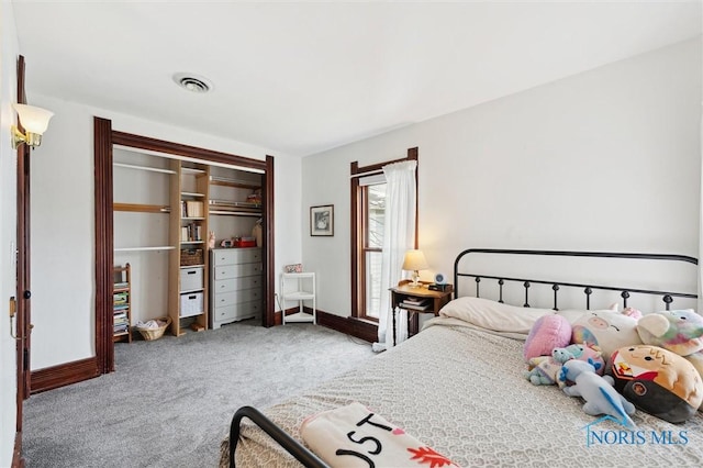 bedroom with a closet, carpet flooring, baseboards, and visible vents