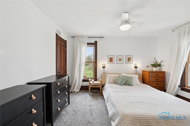carpeted bedroom with visible vents and a ceiling fan