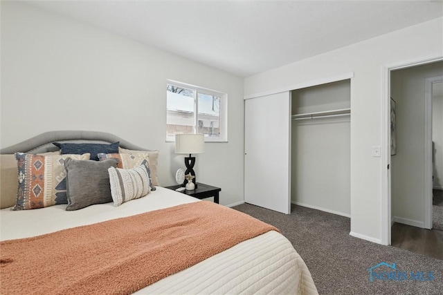 carpeted bedroom with a closet and baseboards