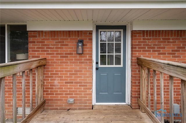 view of exterior entry featuring brick siding