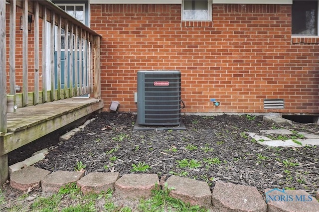 details featuring brick siding and central AC unit