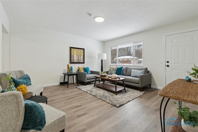 living area featuring baseboards and light wood-type flooring