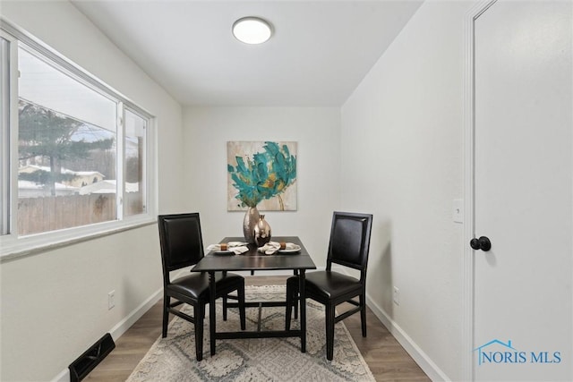 dining area with baseboards and wood finished floors