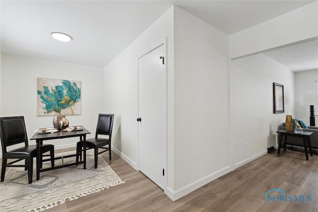 living area with baseboards and wood finished floors
