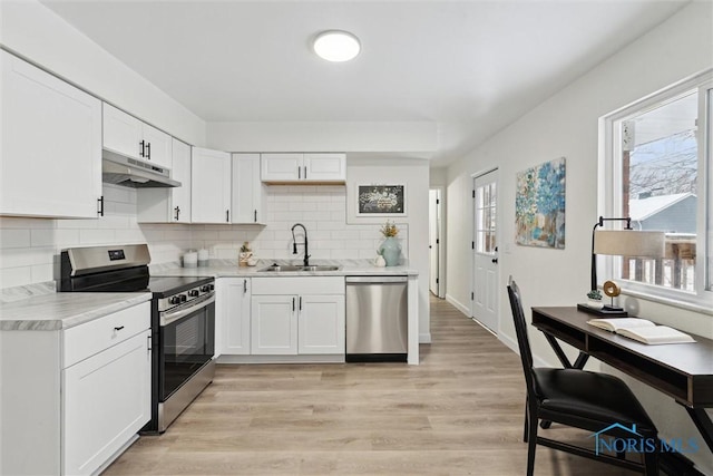 kitchen with a sink, light countertops, under cabinet range hood, white cabinetry, and stainless steel appliances