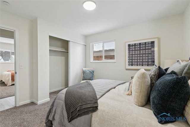 carpeted bedroom featuring a closet and baseboards