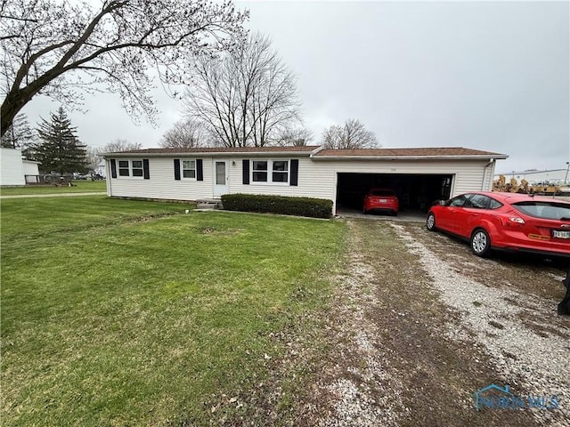 ranch-style home featuring driveway, an attached garage, and a front lawn