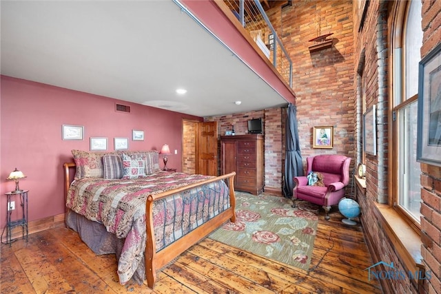 1 S Saint Clair St, Toledo, OH 43604 - bedroom featuring visible vents, baseboards, hardwood / wood-style flooring, and brick wall