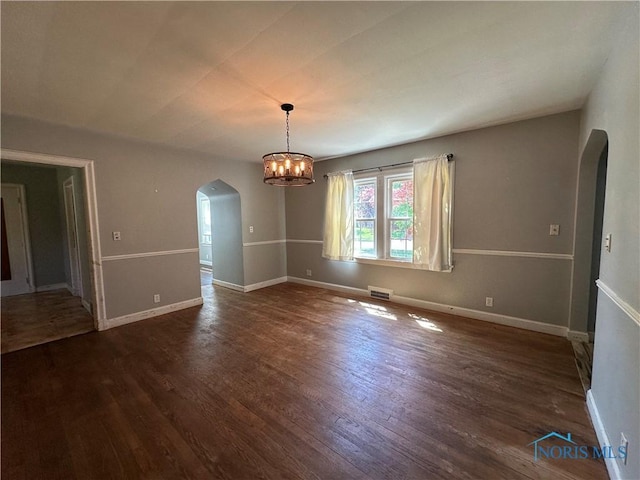 940 N Main St, Fostoria, OH 44830 - unfurnished dining area featuring arched walkways, dark wood finished floors, baseboards, and a chandelier