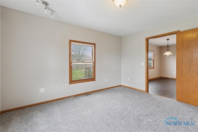 unfurnished room with baseboards and carpet floors