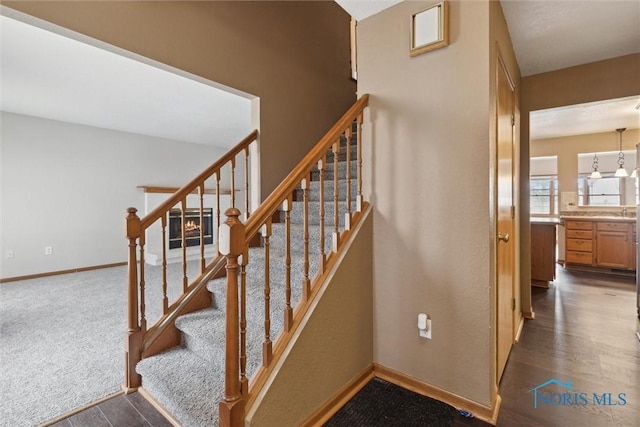 stairway featuring baseboards and wood finished floors