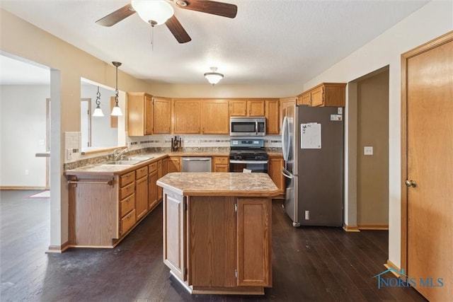 kitchen with ceiling fan, a kitchen island, appliances with stainless steel finishes, a sink, and dark wood-style floors