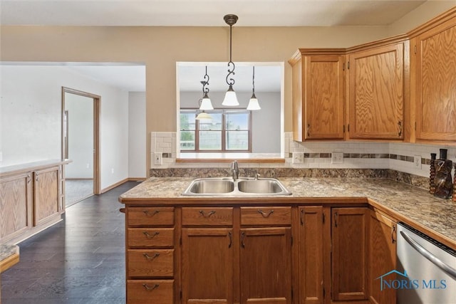 kitchen with tasteful backsplash, decorative light fixtures, dishwasher, a sink, and dark wood-style flooring