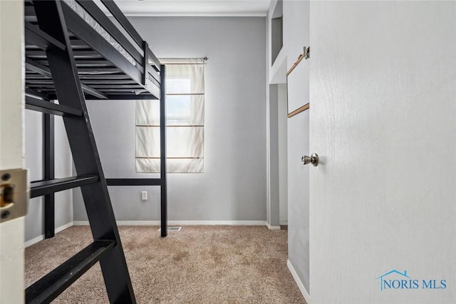 hall featuring carpet flooring and baseboards