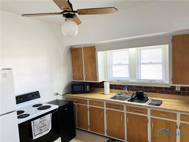 16 College Pl, Defiance, OH 43512 - kitchen with range with electric stovetop, a sink, light countertops, freestanding refrigerator, and black microwave