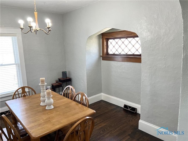 16 College Pl, Defiance, OH 43512 - dining room featuring baseboards, a chandelier, plenty of natural light, a textured wall, and wood finished floors