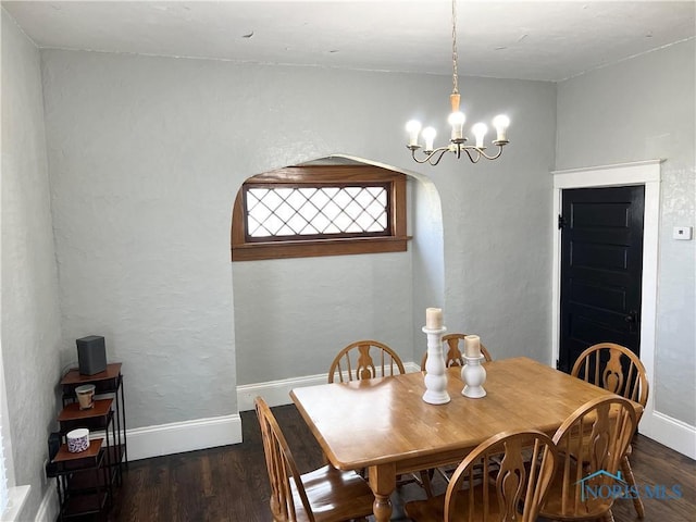 16 College Pl, Defiance, OH 43512 - dining room featuring baseboards, arched walkways, a chandelier, and wood finished floors