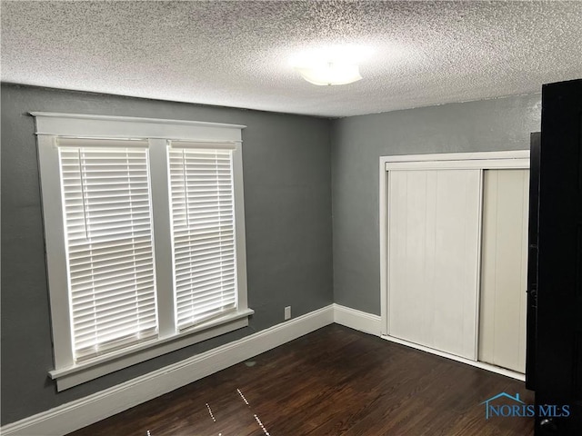 16 College Pl, Defiance, OH 43512 - unfurnished bedroom featuring a textured ceiling, wood finished floors, a closet, and baseboards