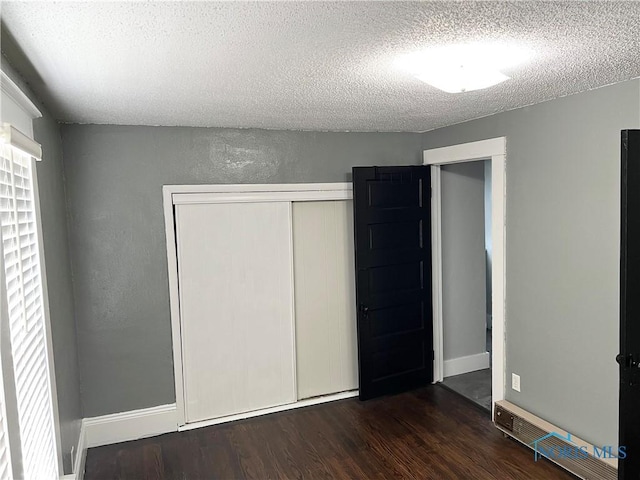 16 College Pl, Defiance, OH 43512 - unfurnished bedroom with a textured ceiling, a closet, and dark wood-style flooring