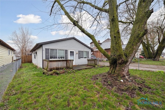 bungalow with a fenced backyard, a front yard, and a deck