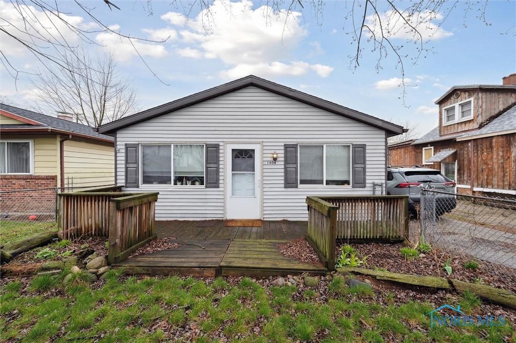 view of front facade featuring fence and a wooden deck