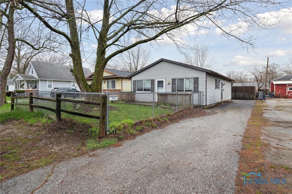 view of front of house featuring a fenced front yard and aphalt driveway