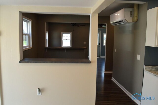 1964 Sudbury Dr, Holland, OH 43528 - hall with a wall mounted air conditioner, dark wood-type flooring, and baseboards