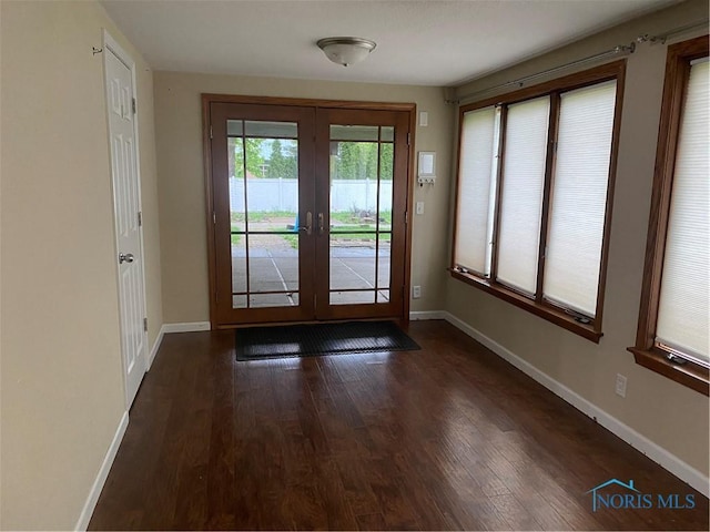 doorway to outside featuring baseboards, french doors, and dark wood-type flooring