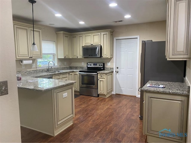 kitchen featuring a sink, light stone counters, visible vents, cream cabinetry, and appliances with stainless steel finishes