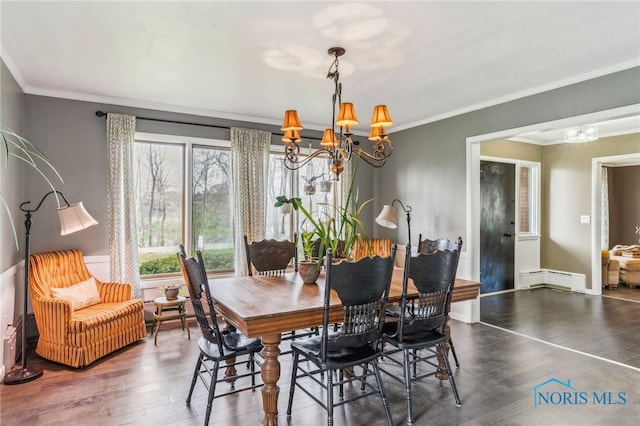 dining room with crown molding, a baseboard heating unit, wood finished floors, and a notable chandelier