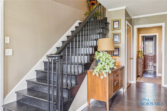 staircase featuring wood-type flooring, baseboards, and crown molding