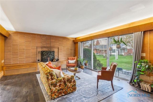 living area with a fireplace, dark wood-style floors, and visible vents