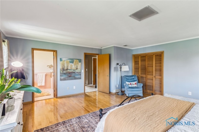 bedroom with a closet, ornamental molding, baseboards, and light wood-type flooring